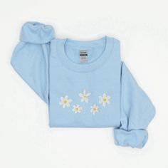 Introducing our Daisies Embroidered Sweatshirt, a delightful addition to your wardrobe that effortlessly combines comfort and style. This 2D Crewneck Sweatshirt is not only a fashion statement but also a thoughtful gift option for your loved ones. With meticulous attention to detail, this sweatshirt is designed to bring joy and warmth to your everyday attire, while showcasing your love for nature and its beautiful creations. Featuring a stunning embroidered daisies design, this sweatshirt immedi Spring Long Sleeve Tops With Embroidered Logo, Long Sleeve Tops With Embroidered Logo For Spring, Trendy Long Sleeve T-shirt With Embroidered Logo, Spring Long Sleeve Sweater With Embroidered Text, Spring Casual Sweatshirt With Embroidered Graphics, Spring Crew Neck Sweatshirt With Embroidered Logo, Trendy Long Sleeve Top With Embroidered Logo, Casual Embroidered Sweatshirt For Spring, Spring Crew Sweatshirt With Embroidered Logo