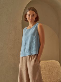 "PRODUCED in 3-5 days FAST & FREE shipping with DHL Express Courier -10% for all items with code \"FAVOURITE\" A sleeveless linen top with a slightly longer back in a subtle steel blue hue is a true charm to any outfit. Cropped waist and relaxed fit will give you comfort on breezy summer days. You can wear the top in colder seasons too by layering it with warm knitwear and trousers.  Details: - 100% Linen - Round neck - Slightly boxy fit - Cropped waist length - Model's height is 160 cm / 5'3'' wears size M - Code: E5002-L532 -126 The top is available in other colors. You can find them in the gallery. If you want to order the top in another color, please specify it in the personalization field. Sizing: This garment is true to size, and we recommend choosing the size you usually wear. If yo Light Blue Relaxed Fit Summer Top, Light Blue Casual Summer Vest, Blue Cropped Vest For Summer, Casual Light Blue Linen Tops, Elegant Blue Linen Top, Relaxed Fit Light Blue Linen Tops, Light Blue Relaxed Fit Linen Tops, Casual Blue Linen Tank Top, Sleeveless Blue Linen Top