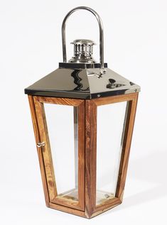 an old fashioned wooden lantern with metal handle and glass panels on the front, set against a white background