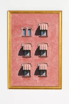 four windows with awnings on a pink wall