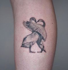 a tattoo on the leg of a person with a bird in it's beak