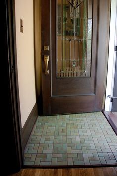 the front door is open and there is a clock on the glass paneled door