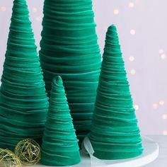 three green christmas trees sitting on top of a white plate