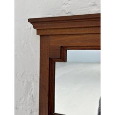 a mirror that is on the wall next to a white brick wall and wooden frame