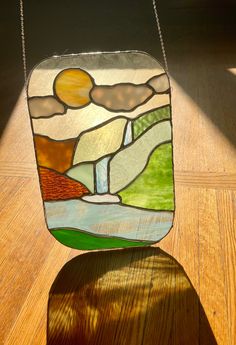 a stained glass vase sitting on top of a wooden table