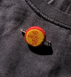 a button with the words no music, no life written on it is attached to a t - shirt