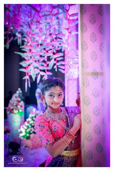 a woman standing next to a wall covered in lights