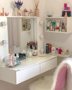 a white vanity with lots of beauty products on it's shelves and shelving