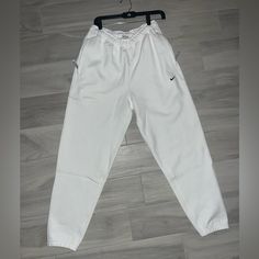 Elevate Your Activewear Game With These Nike Sportswear Solo Swoosh Fleece White Sweatpants For Men. The Cozy Fleece Fabric Will Keep You Warm During Your Workouts, While The Stylish Design Makes Them Perfect For Casual Wear Too. The Nike Brand Name Speaks For Itself In Terms Of Quality, And The Sweatpants Come In Size S, Perfect For A Regular Fit On Men. These Sweatpants Are Ideal For Any Occasion, Whether It Be A Morning Jog Or A Casual Day Out. The White Color And Swoosh Logo On The Side Give White Athleisure Sweats For Jogging, Sporty White Tracksuit For Gym, White Casual Activewear For Jogging, Sporty White Tracksuit For Sports, White Fleece Sweats For Athleisure, Casual White Activewear For Jogging, White Athleisure Tracksuit For Sports, Casual White Tracksuit For Sports, White Nike Bottoms For Jogging