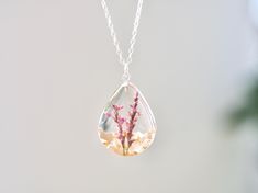 This necklace features Gladiolus, the birth flower for August, carefully preserved in a clear resin pendant. Gladiolus is symbolic of strength of character, faithfulness, moral integrity, and remembrance, making this necklace a perfect personalized birthday gift. Material: 14k gold filled chain and components or Silver, Resin Flower: Real Pressed Flower Chain Length: 18" (45cm)  Pendant Width: 0.79" (2cm) Pendant Height: 0.98" (2.5cm) Every pieces is made by hand and unique, therefore each piece might be slightly different. Comes packed with a gift bag or box. This is a handmade product, there is a tiny possibility of imperfections and micro bubbles. Spiritual Necklaces With Pressed Flowers As Gift, Memorial Flower Pendant Necklace With Birth Flower, Spiritual Style Necklace With Pressed Flowers As A Gift, Memorial Birth Flower Pendant Necklace, Memorial Birth Flower Jewelry, Clear Flower-shaped Birth Flower Jewelry, Clear Flower Shaped Birth Flower Jewelry, Nature-inspired Clear Jewelry For Gifts, Clear Nature-inspired Jewelry For Gift