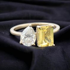 two yellow and white rings on top of a black cloth with a diamond in the middle