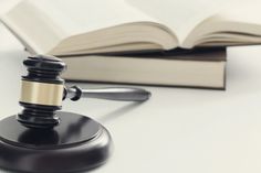 a judge's gavel sitting on top of a table next to an open book