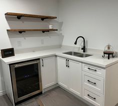 an empty kitchen with white cabinets and stainless steel appliances