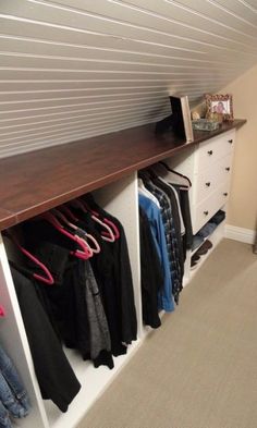 a closet with clothes hanging on the wall