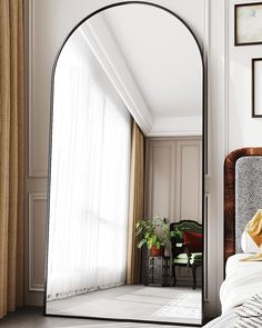 an arched mirror in the corner of a bedroom