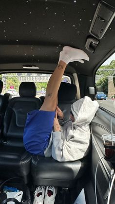 a person laying in the back seat of a car with their feet on the floor