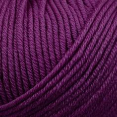 purple yarn is spooled on a white surface