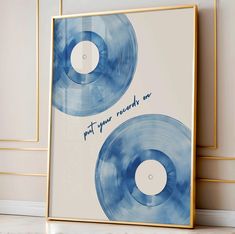 two blue vinyl records with the words put your record on them in gold frames against a white wall