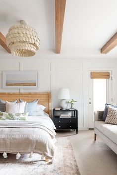 a bedroom with white walls and wood beams