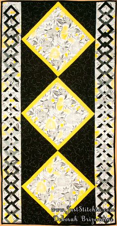 a black and white quilt with yellow accents