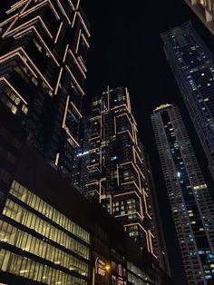 tall buildings are lit up at night in the city