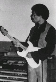 a man playing an electric guitar in front of sound equipment