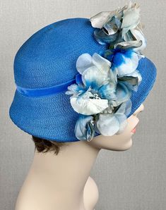 Beautiful vintage hat from the 1960s.  Styled as an asymmetrical cloche with the right side dropping low.  Body is a flexible synthetic straw in a sky blue color.  Right side holds a row of silk and velvet flowers in a blue and ivory color. Interior is finished with a blue petersham ribbon. No Label. Excellent condition.  The only issue is some age and wear on the front flower which you can see in the photographs. Inner circumference is 21 inches.  Measuring on the outside, side to side is 15 1/ Alley Cats, Silk Florals, Color Interior, Alley Cat, Velvet Flowers, Vintage Hat, Ivory Color, Vintage 60s, Hats Vintage