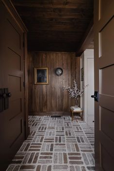 a room with wood paneling and a chair in the corner next to a door