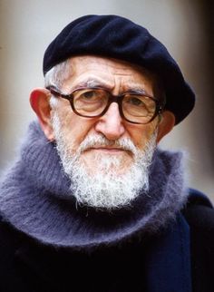 an old man with glasses and a hat is looking at the camera while wearing a scarf