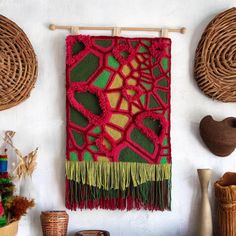 a wall hanging on the side of a wall next to wicker baskets and vases