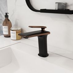 a black faucet sitting on top of a bathroom sink next to a bottle of lotion