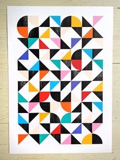 an abstract geometric design with black, red, blue, yellow and green shapes on white paper