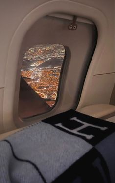 an airplane window looking out at the city lights