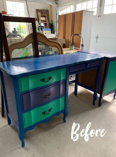 an old desk painted blue and green in a room with other furniture on the floor