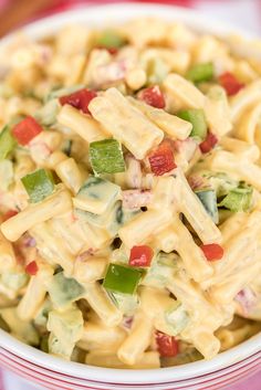 a bowl filled with macaroni salad on top of a red and white checkered table cloth