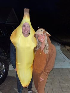 two people in costumes standing next to each other with a banana costume on their head