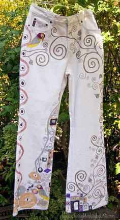 Inspired from the famous Austrian artist Gustav Klimt, the Doodled Denim images are hand drawn with fabric marker.  These Doodled Denims were so much fun to create, being a big fan of  Art Nouveau.   These pre-loved jeans were made by Nevada, have a Boot Cut cut leg and list a size of 10.  However, please review our own measurements and read the measurements information to ensure an accurate fit, as jean sizes vary greatly across designers.  These jeans have no stretch.  Measurements:  Waist=31i White Cotton Jeans With Graphic Print, White Embroidered Cotton Jeans, Artsy Cotton Jeans For Spring, Artistic Cotton Bottoms With Graphic Print, Artistic Cotton Jeans For Summer, Casual Hand Painted Cotton Bottoms, Drawn On Jeans, Klimt Inspired, Fashion Over 50 Fifty Not Frumpy