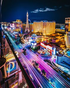 the las vegas strip is lit up at night with traffic and buildings in the background