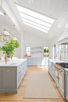 a large kitchen with white walls and wooden flooring, along with an area rug