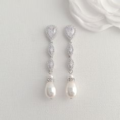 Slim & Long Silver Pearl Earrings for a Perfect Bridal Looks These silver pearl earrings add a delicate finish to complete your bridal and wedding day look. These silver pearl drop earrings are slim and long, measuring 2 inches or 5 cms and about 7mm wide. These silver and pearl earrings are made with marquise cubic zirconia crystal drops with teardrop ear post and teardrop pearl drops in white and cream pearl colors. The combined effect of silver, cubic zirconia sparkle and a soft glow from Pearl Wedding Jewelry Sets, Silver Pearl Drop Earrings, Bridal Jewelry Pearl Sets, Silver Bridal Jewellery, Wedding Jewellery Designs, Rose Gold Pearl, Pearl Bridal Jewelry, Silver Pearl Earrings, Pearl Earrings Wedding