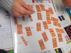 a person is working on some type of game with orange squares and numbers that are arranged in rows