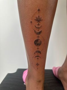 a woman's leg with tattoos on it and the moon, stars, and crescents