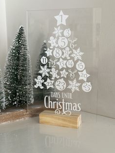 a clear acrylic christmas tree with white numbers and snowflakes on it