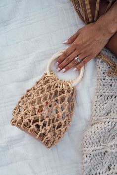 This Macrame Bucket Bag is an absolute beach must-have! The wooden handle, linen lining and tiny size make it the perfect pick for all your summer shenanigans. It's lightweight and fabulously fashionable - looks amazing with any look! Eco-friendly Macrame Straw Bag For Vacation, Eco-friendly Macrame Straw Bag For Summer, Natural Crochet Bag For Beach Season Outings, Handwoven Natural Bags For Summer Outings, Beige Straw Bag With Braided Handles For Summer Outings, Natural Crochet Bag With Bamboo Handle For Beach, Natural Crochet Bag For Summer Outings, Natural Macrame Beach Bag For Everyday Use, Natural Woven Crochet Bag For Summer Outings