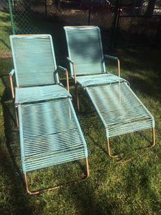 two lawn chairs are sitting in the grass