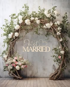 a wedding arch with flowers on it and just married written in gold lettering over the top