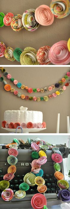 a white cake sitting on top of a table next to two candles and paper flowers