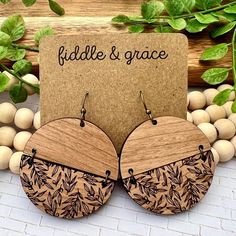 the wooden earrings are made from wood and have floral designs on them, along with a card