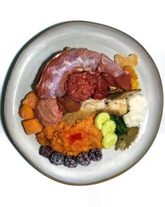 a white plate topped with different types of meats and veggies on top of it