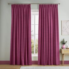 a living room with pink curtains and a white rug